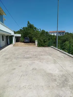 a parking lot with a car parked in a driveway at Kuća Duskic in Kunje