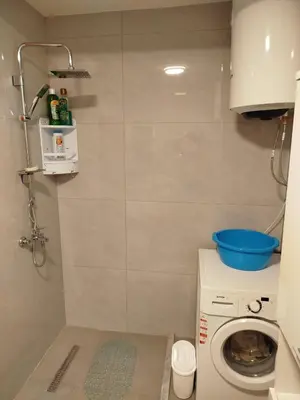 a small bathroom with a washing machine and a washer at Kuća Duskic in Kunje