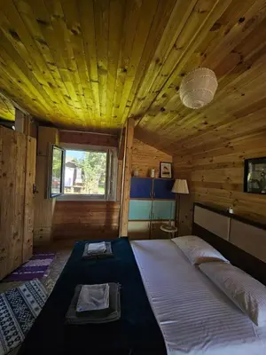 a bedroom with a large bed in a wooden room at Sunrise in Ulcinj