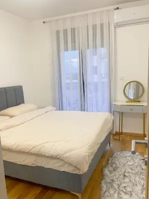 a bedroom with a bed and a window at Urban Nest - New City in Podgorica