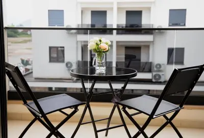 a table with a vase of flowers on a balcony at Urban Nest - New City in Podgorica