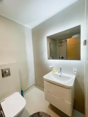 a bathroom with a sink and a toilet and a mirror at Urban Nest - New City in Podgorica