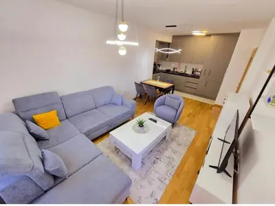 a living room with a blue couch and a table at Urban Nest - New City in Podgorica