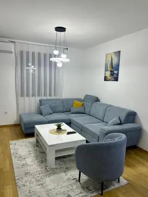 a living room with a blue couch and a table at Urban Nest - New City in Podgorica
