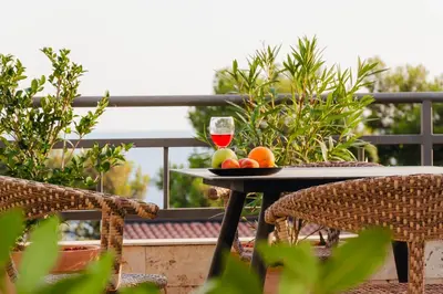 a table with a glass of wine and fruit on it at Sea View Retreat with Pool in Bar