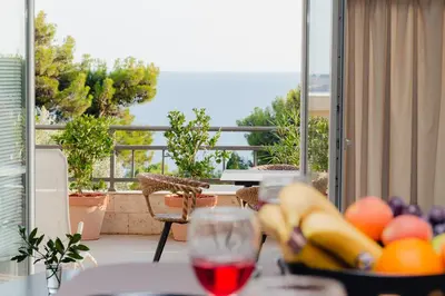 a table with a bowl of fruit and a glass of wine at Sea View Retreat with Pool in Bar