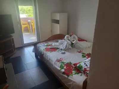 a bedroom with a bed with a dress on it at Asko Villa Apartment in Ulcinj