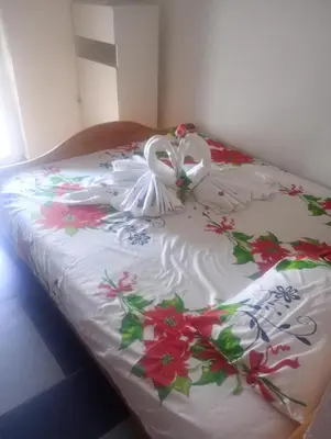 a bed with a white blanket with flowers on it at Asko Villa Apartment in Ulcinj