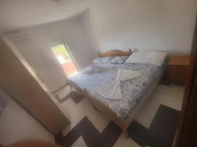 a small bedroom with a bed with a white umbrella on it at Asko Villa Apartment in Ulcinj