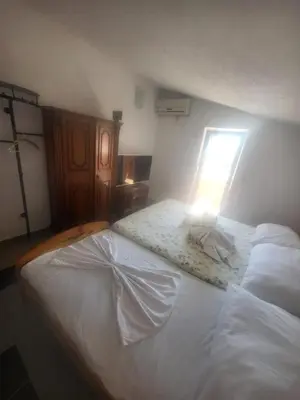 a bedroom with a white bed with a light on it at Asko Villa Apartment in Ulcinj