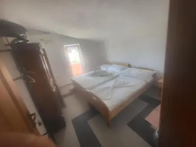 a small bedroom with a bed and a window at Asko Villa Apartment in Ulcinj