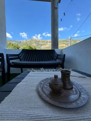 a table with a plate and two vases on it at Apartmani Đurović - Sutomore in Bar