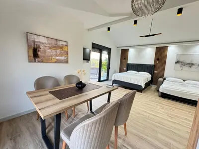 a living room with a dining table and a bedroom at Apartments Lj in Ulcinj