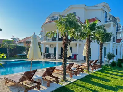 a villa with a pool and chairs and a umbrella at Apartments Lj in Ulcinj