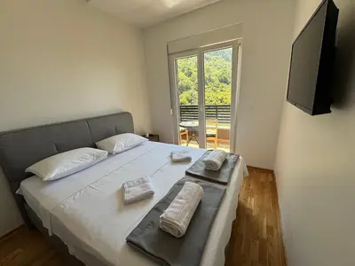 a bedroom with a bed with two towels on it at Comfort Stylish Apartment IVSOLE in Budva