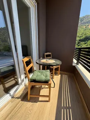 a room with a table and a chair and a table and window at Comfort Stylish Apartment IVSOLE in Budva