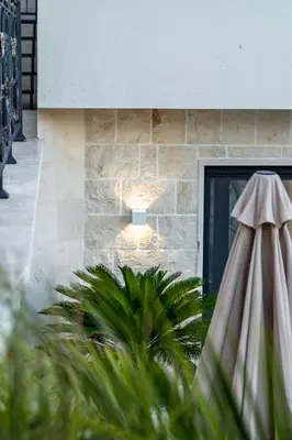 a building with a stone wall and a door at Lux Apartments Villa B-L-S in Budva