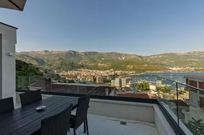 a balcony with a table and chairs and a view at Lux Apartments Villa B-L-S in Budva