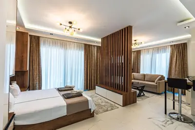 a bedroom with a bed and a couch and a desk at Lux Apartments Villa B-L-S in Budva