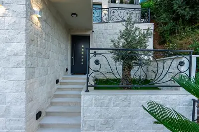 a staircase leading to a house with a bench at Lux Apartments Villa B-L-S in Budva