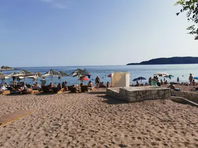 a group of people sitting on a beach at Apartment Aleksic Becici in Becici