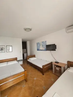 a room with two beds and a flat screen tv at Apartment Aleksic Becici in Becici