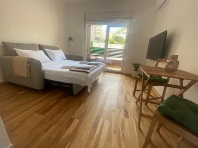 a bedroom with a bed and a television in it at Stylish Studio IVSOLE in Budva