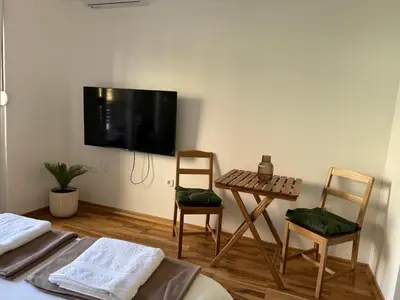 a room with two chairs and a table with a tv on the wall at Stylish Studio IVSOLE in Budva