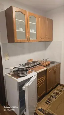 a kitchen with a stove and wooden cabinets at BETA Hause in Ulcinj