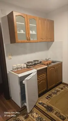 a kitchen with wooden cabinets and a stove top oven at BETA Hause in Ulcinj
