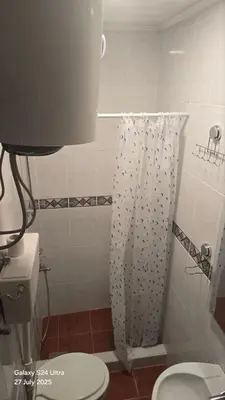 a bathroom with a toilet and a shower curtain at BETA Hause in Ulcinj