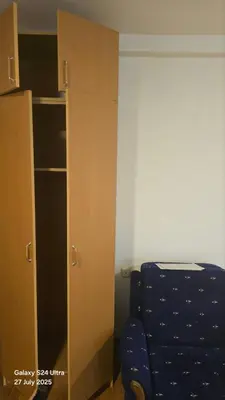 a room with a blue chair next to a cabinet at BETA Hause in Ulcinj
