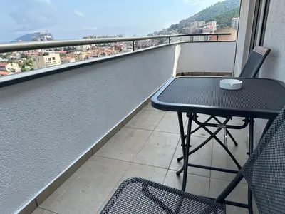 a table and chairs on a balcony with a view at Stunning view designer apartment in Budva