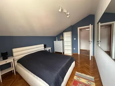 a bedroom with a bed and a blue wall at Stunning view designer apartment in Budva