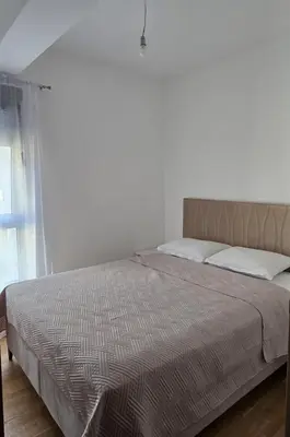 a bed in a white room with a large bed sidx sidx sidx at Monika Dream Apartment in Budva