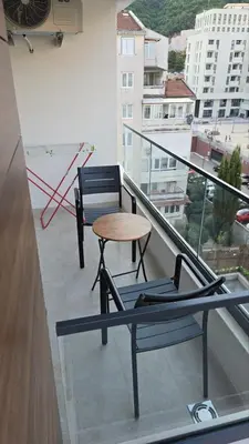 a balcony with two chairs and a table on it at Monika Dream Apartment in Budva