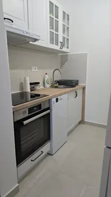 a kitchen with white cabinets and a stove top oven at Monika Dream Apartment in Budva