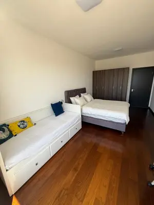 two beds in a room with wooden floors at Sargo Apartman Bar in Bar