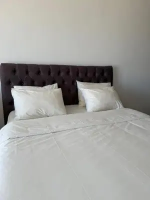a large bed with white sheets and pillows at Sargo Apartman Bar in Bar