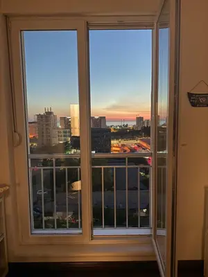 two windows in a room with a view of a city at Sargo Apartman Bar in Bar