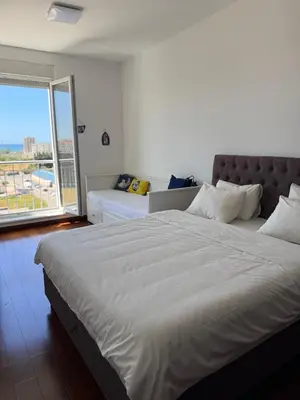 a bedroom with a large bed and a large window at Sargo Apartman Bar in Bar