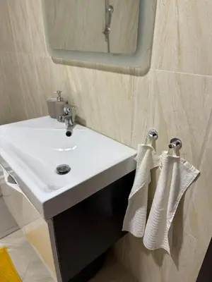 a bathroom with a sink and a mirror and towels at Sargo Apartman Bar in Bar