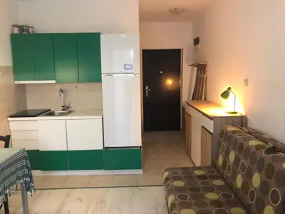a kitchen with green cabinets and a white refrigerator at Studio Budva in Budva