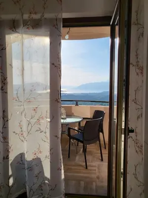 a view from the balcony of a house with a table and chairs at Sunset Vista Kotor in Kotor