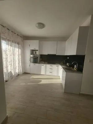 a kitchen with white cabinets and a tile floor at Sunset Vista Kotor in Kotor