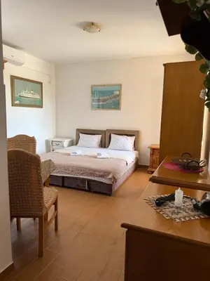 a bedroom with a bed and a table and chairs at Monte Lastva Apartments in Podlastva