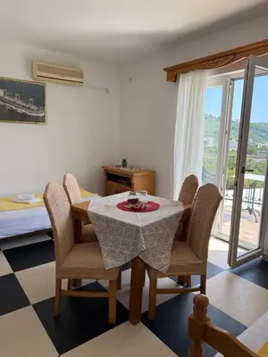 a dining room with a table and chairs at Monte Lastva Apartments in Podlastva