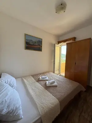 a bedroom with a bed with two towels on it at Monte Lastva Apartments in Podlastva