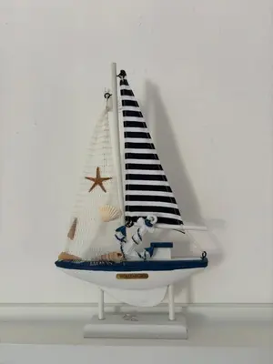 a small toy sailboat on a white shelf at Bloom Home Bar in Bar