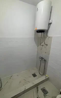 a shower in a bathroom with a white wall at Bloom Home Bar in Bar